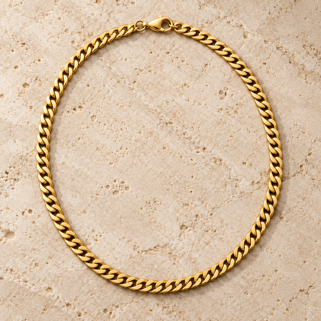 The Classic Curb — Gold-tone detail view on cream stone