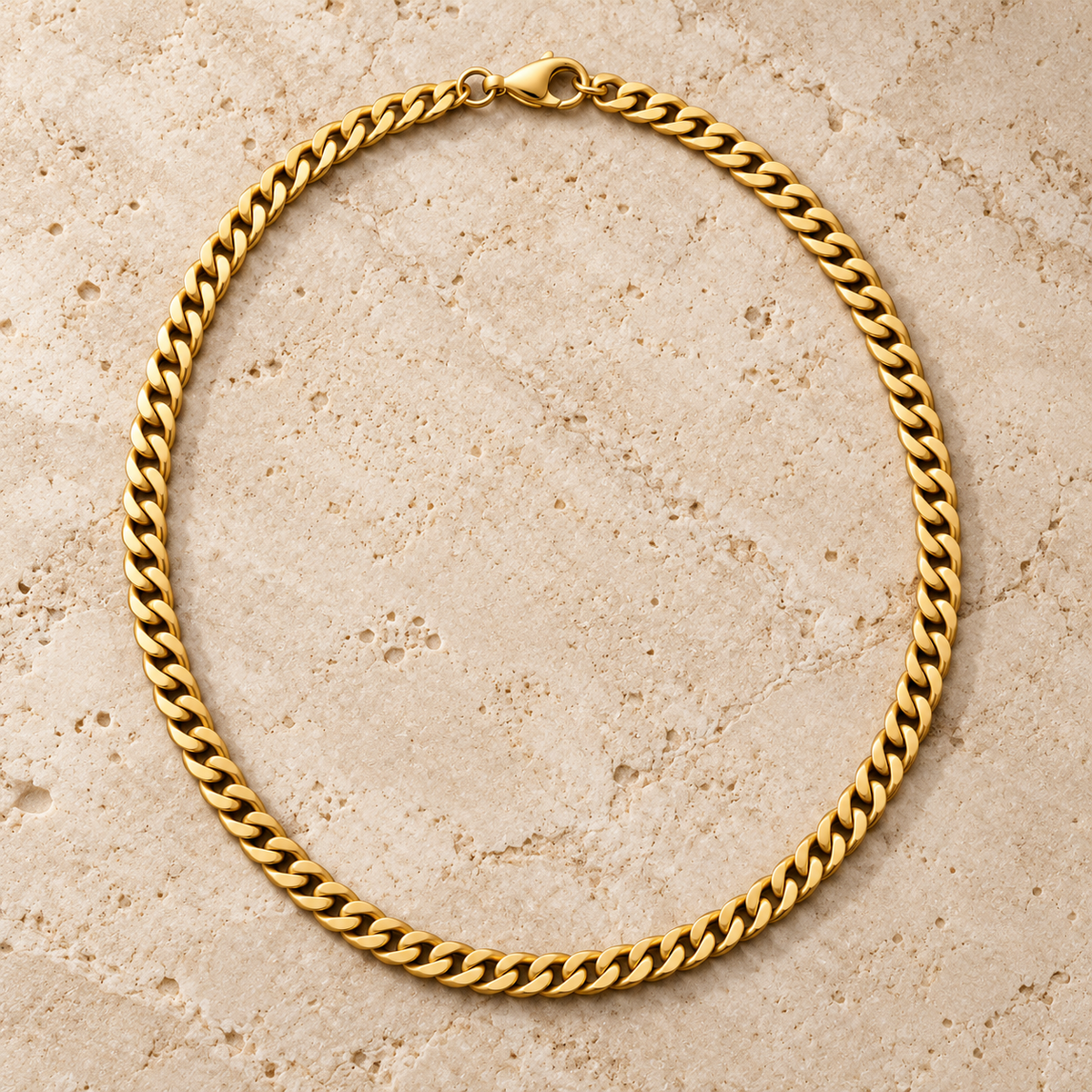 The Classic Curb — Gold-tone detail view on cream stone