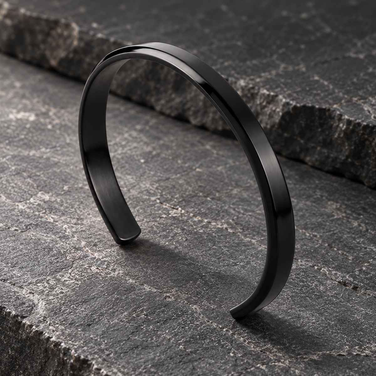 The Arc Cuff — Black editorial view on charcoal stone
