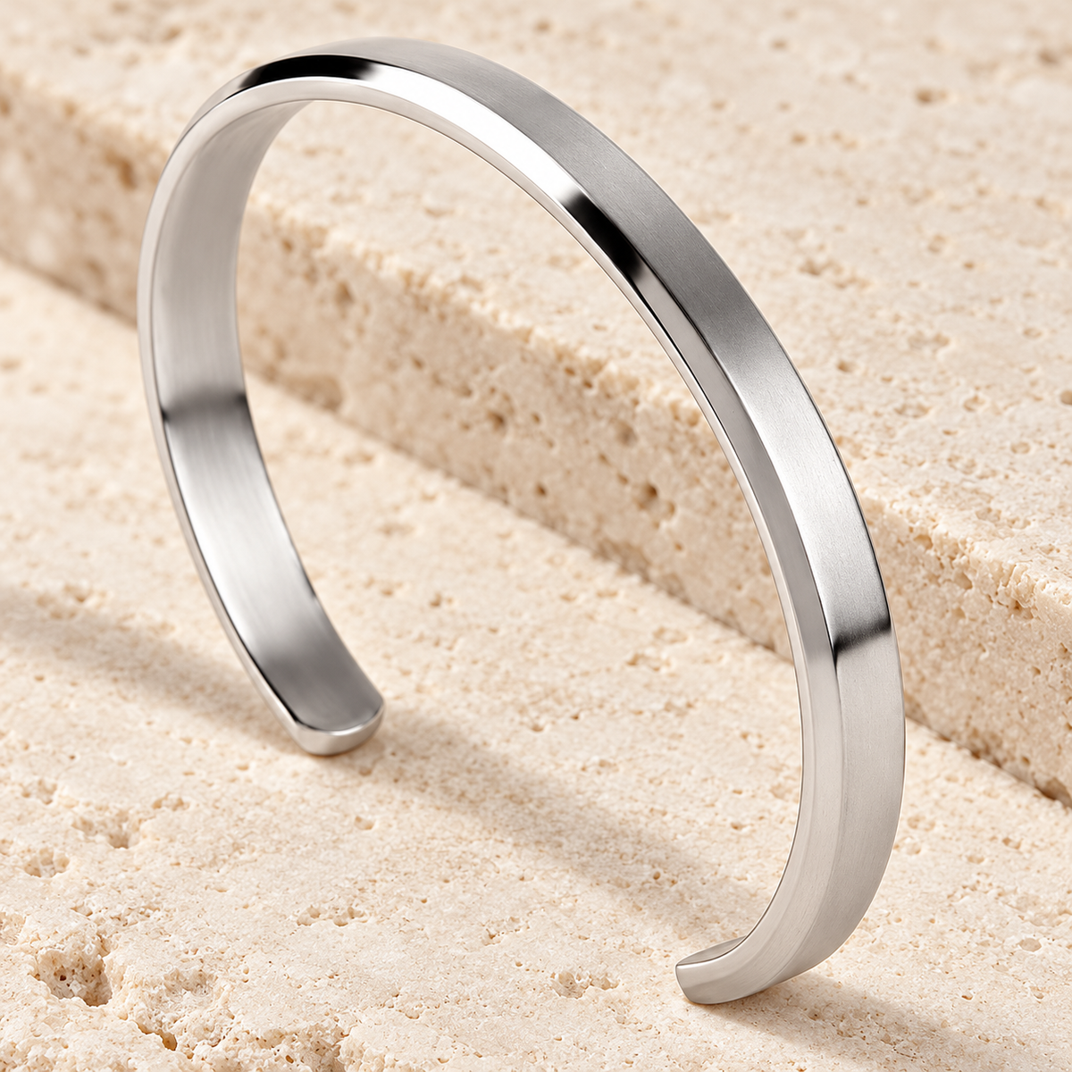 The Arc Cuff — Silver-tone detail view on cream stone