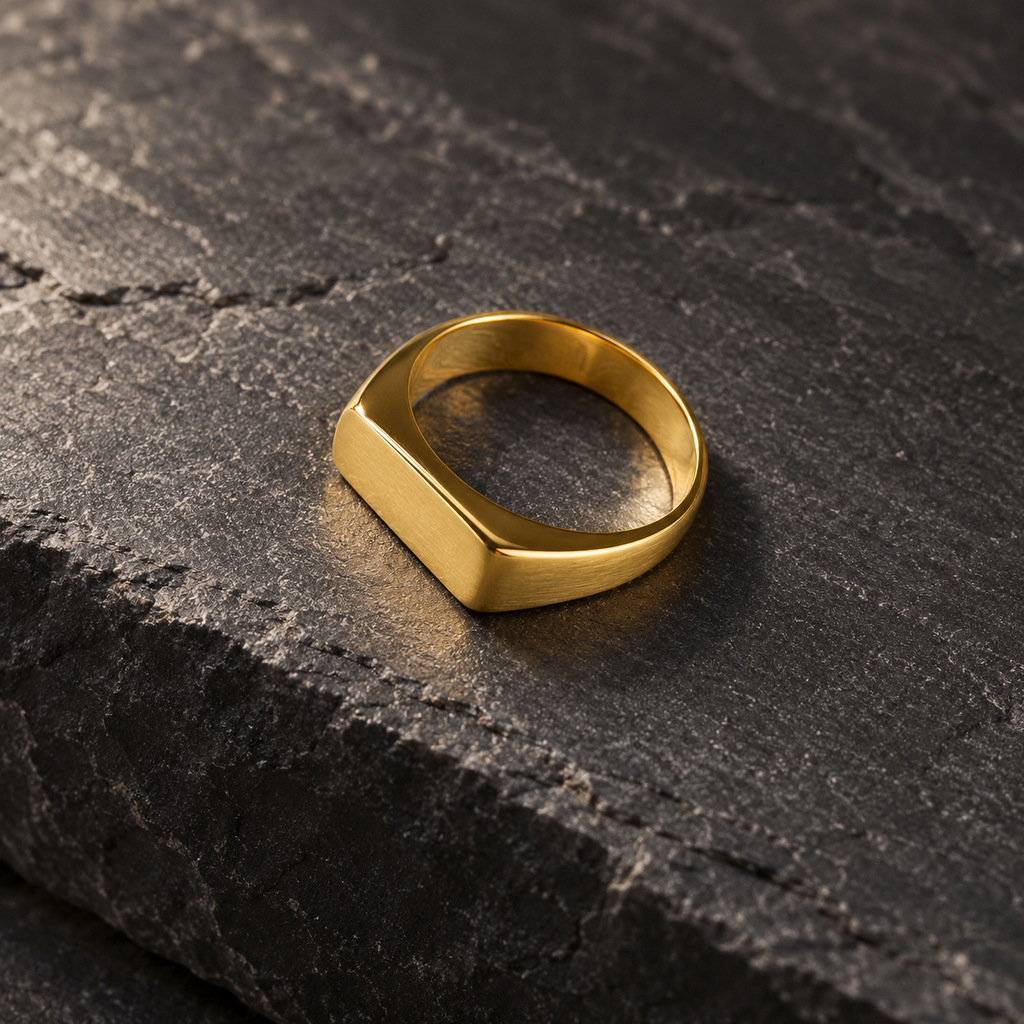 The Frame Signet — Gold-tone editorial view on charcoal stone