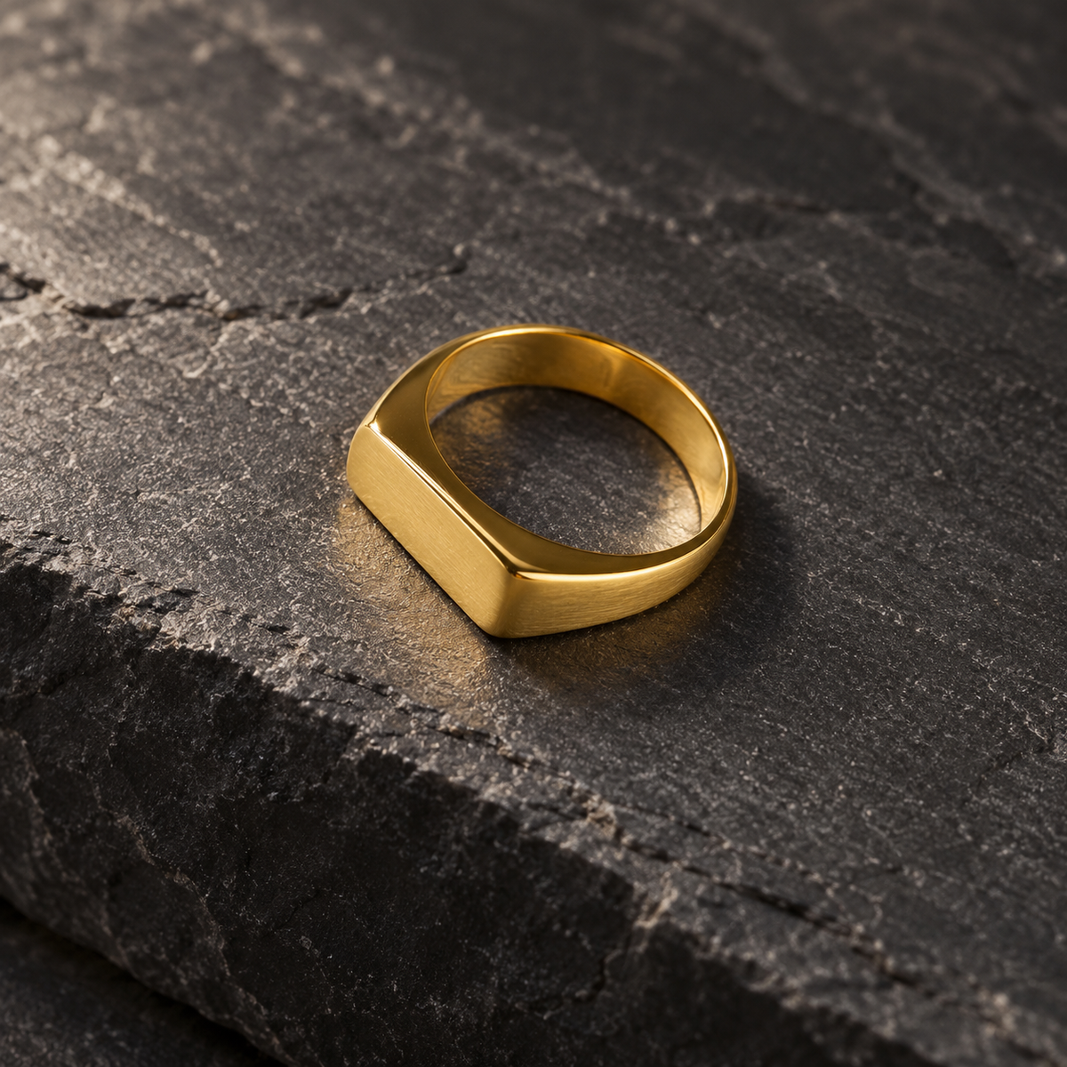 The Frame Signet — Gold-tone editorial view on charcoal stone